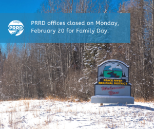 Snow covered ground and a backdrop of trees, with a concrete sign in the foreground that reads Peace River Regional District welcomes you" and a banner above that reads PRRD offices closed on Monday, February 20 for Family Day.